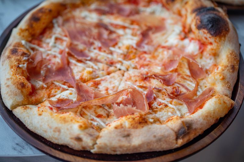 Artisan pizza being sliced at Punch pizza