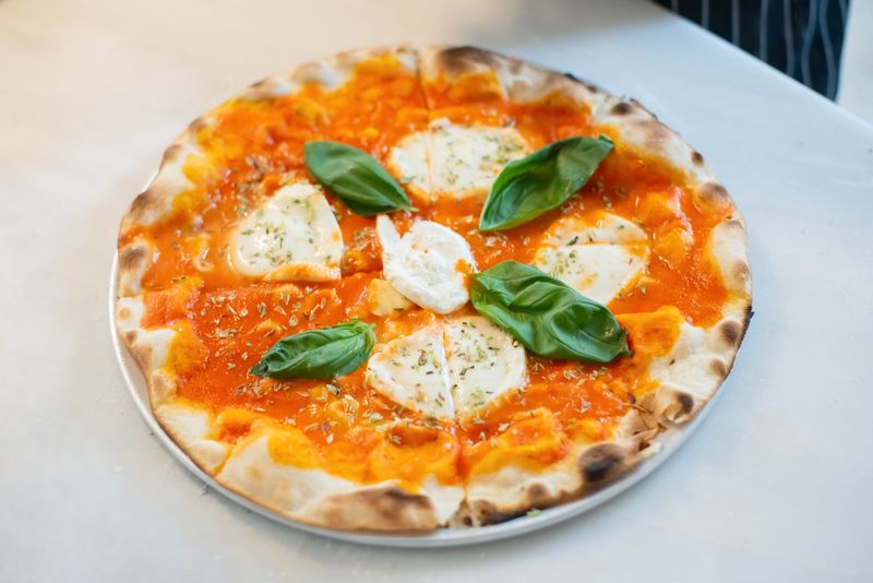 Signature Margherita punch pizza with fresh basil and mozzarella